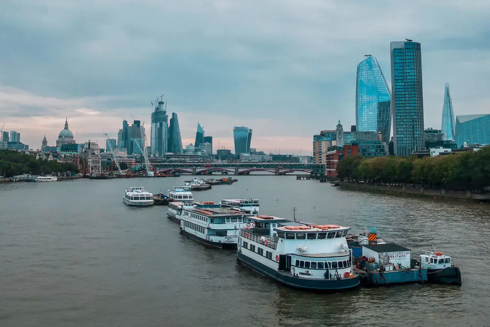 Passenger boats on the River Thames beneath the London skyline